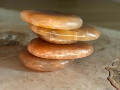 Pierres de lune pêche naturelles de qualité A+, aux nuances pêche et crème, disposées sur un fond en bois naturel.